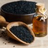 Black Cumin Seeds in bowl and black cumin seed oil in glass jar