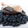 Blueberry seed oil in glass bowl with blueberries